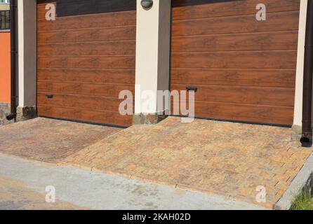 Close up on modern house two garage doors entrace with rain gutter pipes and pavement. Stock Photo