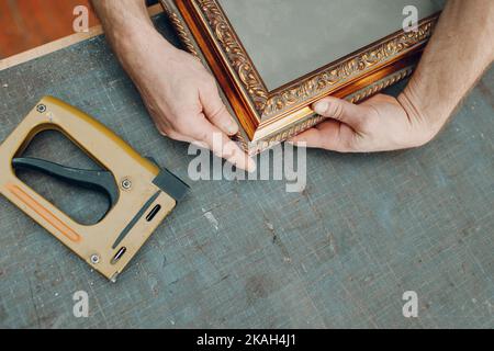 Framing Workshop. Making assembly stapler brackets baguette handmade picture frame at studio. Stock Photo