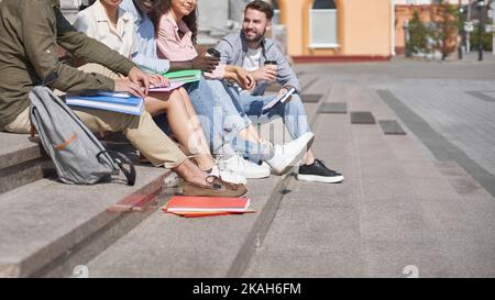 group of students communicates sitting on the steps Stock Photo