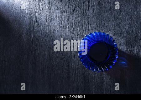 Bright blue glass saucer on black wooden background. Stock Photo