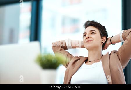 Light tomorrow with today. a young designer looking relaxed at her desk. Stock Photo
