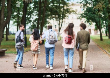 blurry image of students are chatting while walking through the park . Stock Photo