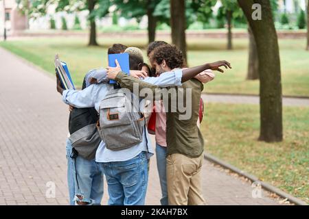 group of happy young people standing in a circle. Stock Photo