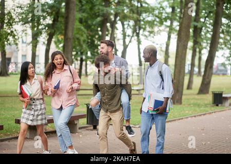 student friends are having fun chatting on the go . Stock Photo