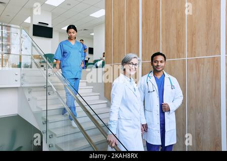 Two doctors standing on stairs in hospital while working day. Healthcare workers. medical worker day Stock Photo