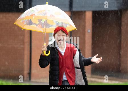 Haverhill, Suffolk, UK. 3rd November 2022. Ivy Mitchell, 7 is all smiles as she skips to school in the heavy rain this morning. Credit: Headlinephoto/Alamy Live News. Stock Photo