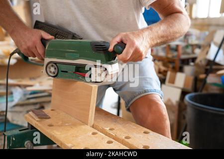 Close up of a carpenter working on wood craft at workspace with professional tools for crafting. Stock Photo