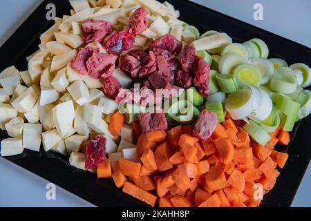 Ingredients for a stew, carrots, turnip, leaks, beef ready to go into slow cooker. Stock Photo