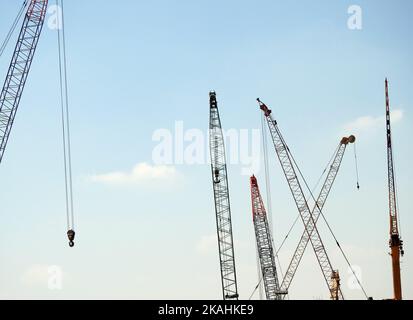 Various mobile wire cranes at a construction site at a factory that provides efficient and convenient lifting and transportation of different heavy ob Stock Photo