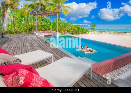 Breakfast in resort swimming pool, floating breakfast in luxury tropical resort. Table floating on calm pool water, healthy breakfast and fruit plate Stock Photo