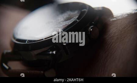 Extreme close-up of blurry looking wristwatch with water particles, wearing on the arm, background concept Stock Photo