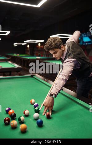 Portrait of man playing billiards Stock Photo
