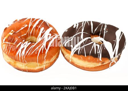 Ring donuts with brown, caramel and white chocolate sauce, A glazed, yeast raised, American style ring doughnuts, type of food made from leavened deep Stock Photo