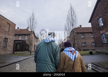 Two former prisoners take a walk in the stretts of the Auschwitz concentration camp, during the celebrations of the 71st anniversary of the liberation of Auschwitz in Oswiecim village, Poland, on January 27, 2016. In their scarfs, the prisoner number when they were prisoners in the camp. (Photo by Celestino Arce/NurPhoto)  Stock Photo
