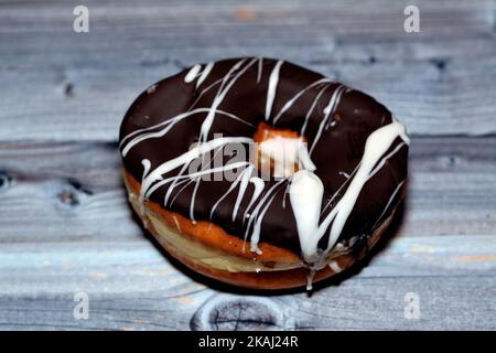 Brown and white chocolate ring donut, A glazed, yeast raised, American style ring doughnut, type of food made from leavened deep fried dough sweet sna Stock Photo