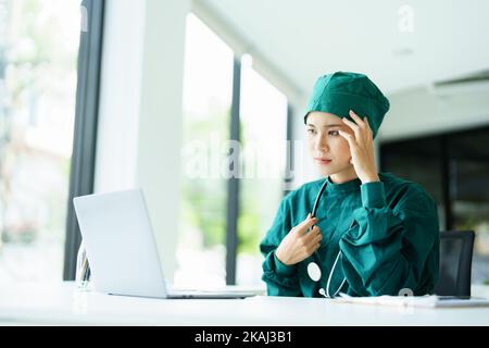 doctor using a computer and showing anxiety over patient information Stock Photo