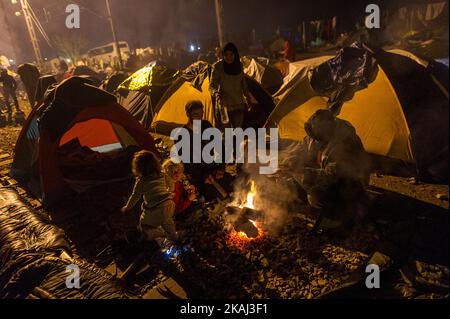 A family sits around a bonfire among other migrants and refugees, at the makeshift camp of the Greek-Macedonian border, near the village of Idomeni, on March 10, 2016, where thousands of refugees and migrants are trapped by the Balkans border blockade. The head of the UN refugee agency on March 8 said he was 'deeply concerned' by a proposed deal between the EU and Ankara to curb the migrant crisis that would involve people being sent back to Turkey. (Photo by Markus Heine/NurPhoto) *** Please Use Credit from Credit Field ***