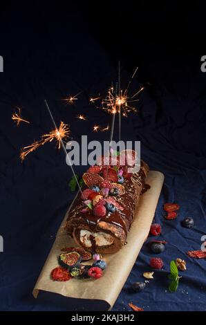 Chocolate roll cake with mascarpone cream, forest fruits and mint Stock Photo