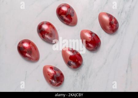 The set of chocolate easter eggs in red color on the table Stock Photo