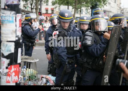Riot police plucks a stamp pasted by a demonstrator.  CGT unionists Marched against Labour law this Wednesday, 23 June 2016 in Paris, next to the Place of La Bastille. Today's march will be the 10th in a wave of protests against the government's disputed labour reforms that kicked off in March, with many descending into violence, notably in Paris and the western cities of Nantes and Rennes.  (Photo by Emilio Espejel/NurPhoto) *** Please Use Credit from Credit Field *** Stock Photo