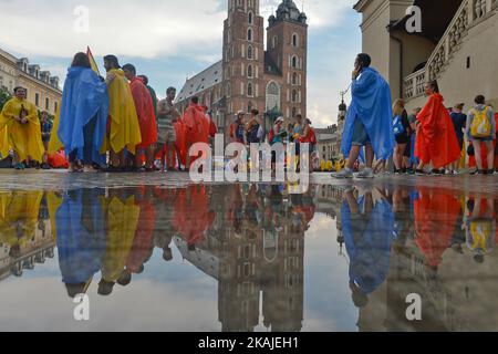 Pilgrims from all around the world surprised by a rain in the center of Krakow ahead  of the official opening Mass and the World Youth Day 2016 in Blonia Park in Krakow  On Tuesday, 26 July 2016, in Krakow, Poland. Photo by Artur Widak *** Please Use Credit from Credit Field *** Stock Photo