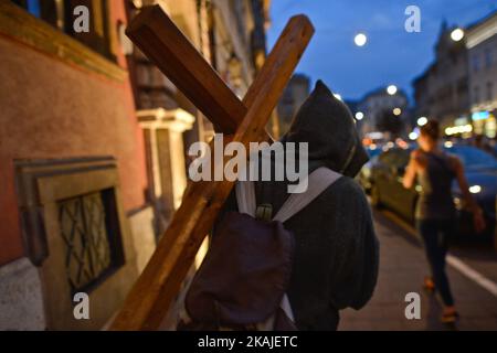 A pilgrim with a cross in Krakow's city center on the day when Pope Francis meets with thousands of young pilgrims from all around the world during the Way of the Cross in Krakow's Blonia Park On Friday, 29 July 2016, in Krakow, Poland.  Stock Photo