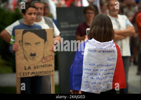 A women wearing the French flag takes a picture of a protester holding a placard depicting Manuel Valls as Adolf hitler. As the socialist party and the government make its comeback from holidays in the town of Colomiers near Toulouse with the presence of Manuel Valls, prime minister along several ministers, trade unionists gathered in order to protest against the Hollande's policies and the El-Khomri law on labour. Colomiers. France. August 29th, 2016. (Photo by Alain Pitton/NurPhoto) *** Please Use Credit from Credit Field *** Stock Photo