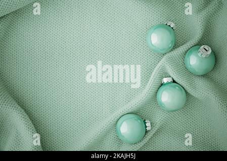 Beautiful Christmas mint colored balls on a knitted mint fabric.. Copy space. Place for text. Stock Photo
