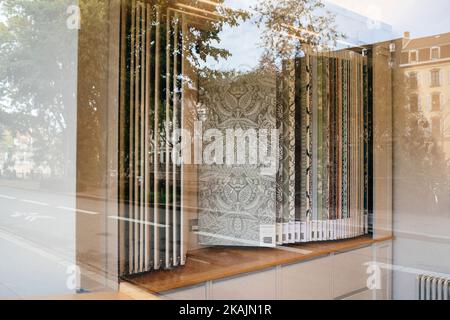 Strasbourg, France - Oct 28, 2022: View through glass showcase of Farrow and Ball luxury British wallpaper - refelction of the city Stock Photo
