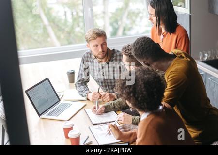 project manager is explaining something to young employees . Stock Photo