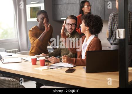 business colleagues giving each other a high five. Stock Photo