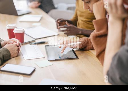 business team with a digital tablet works discussing financial data. Stock Photo