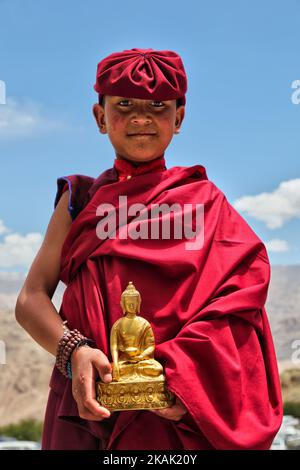 Young Buddhist monk holding a small golden Buddha statue at the Hemis Monastery (Hemis Gompa) in Hemis, Ladakh, Jammu and Kashmir, India. Behind are the magnificent mountains surrounding the Indus Valley. (Photo by Creative Touch Imaging Ltd./NurPhoto) *** Please Use Credit from Credit Field *** Stock Photo