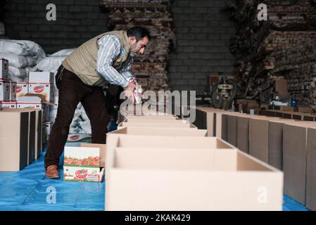 Volunteers from Iraqi NGO RNVDO humanitarian aid distribution in their warehouse in Erbil, on December 25, 2016. Boxes containing food and hygiene kits will be distributed among civilians who had to flee from troubled provinces of Iraq but also return to their homes. With tens of thousands from Mosul now adding to the four million IDPs already in the country, IraqÂ’s displacement crisis is unsustainable,Â’ says Mark Lattimer, MRGÂ’s Executive Director. Â‘As temperatures drop and large numbers of IDPs are prevented from registering to receive state aid, Iraq is facing a humanitarian tragedy th Stock Photo