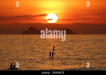 Sunset on the horizon, behind the Cagarras Islands, on Ipanema Beach. Sunset on a sunny day in Rio de Janeiro. Cariocas and tourists watch the sun set on the horizon this Wednesday afternoon (28) at Ipanema Beach, Rio de Janeiro, Brazil, December 28, 2016. (Photo by Luiz Souza/NurPhoto) *** Please Use Credit from Credit Field *** Stock Photo