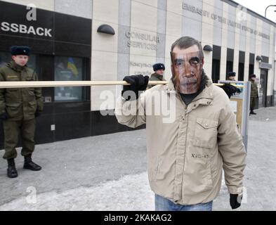 An activist wears a mask of former US President Barack Obama and holds a pilgrim's scrip,during a rally in front the US Embassy in Kiev,Ukraine,20 January, 2017. Some Ukrainian activists gathered for rally in front of the US embassy in Kiev to greet to US President-elect Donald Trump with his inauguration,and say goodbye to outgoing US President Barack Obama. (Photo by STR/NurPhoto) *** Please Use Credit from Credit Field *** Stock Photo