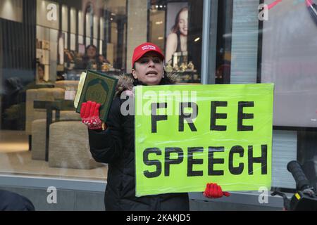 Iranian woman holding a copy of the Quran and a sign with the words 'Free Speech' as she yells anti-Muslim rhetoric about Muslims planning terror attacks in Canada on February 04, 2017 in downtown Toronto, Ontario, Canada. (Photo by Creative Touch Imaging Ltd./NurPhoto) *** Please Use Credit from Credit Field *** Stock Photo