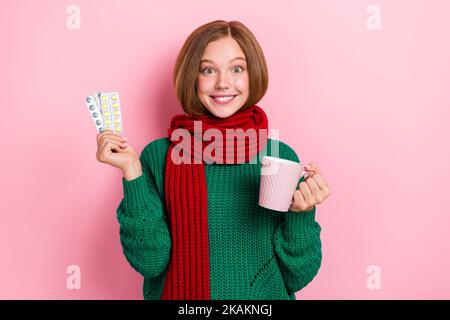 Photo of impressed funky girl dressed knitted pullover scarf drinking hot tea vitamins isolated pink color background Stock Photo