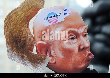 At a Feb. 25, 2017 Affordable Care Act repeal protest rally in Philadelphia, PA, artist Carla Krash holds up a sign with a cartoon image of Donald Trump, that includes a movable hair piece. (Photo by Bastiaan Slabbers/NurPhoto) *** Please Use Credit from Credit Field *** Stock Photo