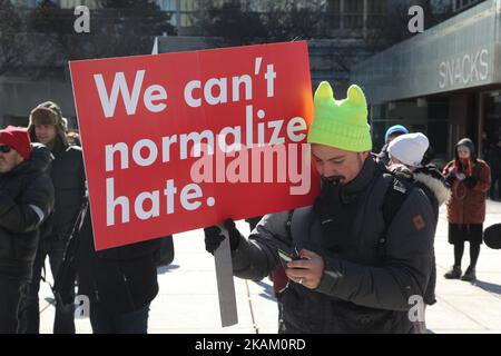 Pro-Muslim protestor carrying a sign saying 'We Can't Normalize Hate' as opposing groups of protesters clashed over the M-103 motion to fight Islamophobia during pro-Muslim and anti-Muslim demonstrations in downtown Toronto; Ontario; Canada; on March 04; 2017. Canadians across the country staged similar protests against Islam; Muslims; Sharia Law and M-103. These protests were met by counter protests by those supporting Muslims and in favour of M-103. M-103 is a private members motion put forth by Liberal MP Iqra Khalid that asks the government to 'recognize the need to quell the increasing pu Stock Photo