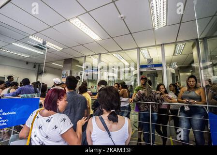 Customers stand in line to speak to an employee about withdrawing money from the Workers Severance Fund (FGTS) inside a Caixa Economica Federal bank branch in Sao Paulo, Brazil, on Friday, March 10, 2017. The Government releases from this Friday the withdrawals of inactive accounts of the Fund for the Guarantee of Time of Service (FGTS) - promised by President Michel Temer in (MP 763/16) is expected to benefit 30.2 million workers and to inject about 30 billion reais into the economy, according to the authorities. The branches of the Federal Savings Bank opened in advance, at 8 am (Brasília ti Stock Photo
