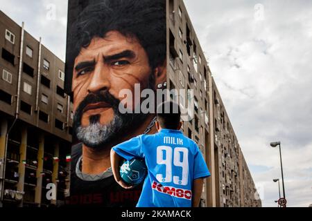 A children that dribble of Taverna Del Ferro, San Giovanni a Teduccio, peripheral of Naples EST on March 29, 2017 in front a Graffiti Revolucionario by Jorit, hand painted on wall with spray cans, Diego Armando Maradona on wall of a building. (Photo by Paolo Manzo/NurPhoto) *** Please Use Credit from Credit Field *** Stock Photo