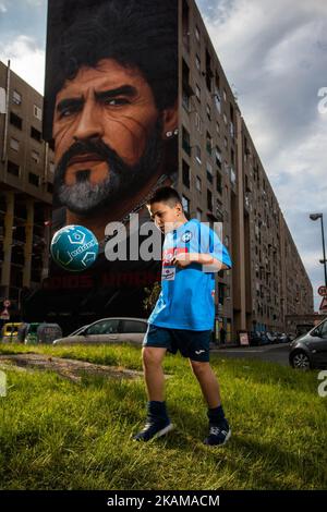 A children that dribble of Taverna Del Ferro, San Giovanni a Teduccio, peripheral of Naples EST on March 29, 2017 in front a Graffiti Revolucionario by Jorit, hand painted on wall with spray cans, Diego Armando Maradona on wall of a building. (Photo by Paolo Manzo/NurPhoto) *** Please Use Credit from Credit Field *** Stock Photo