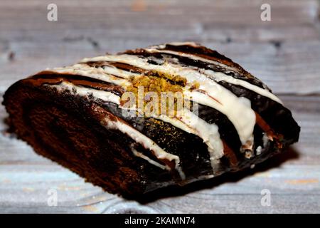 A chocolate cake roll Swiss roll, combination of light chocolate sponge cake with sweet vanilla whipped cream and chocolate ganache dessert, covered w Stock Photo