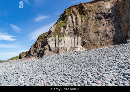 Scenic View of Greencliff Beach, With Pebbles, Crumbling Cliff and Coastal View Towards Croyde at Low Tide: Greencliff, Near Bideford, Devon, UK. Stock Photo
