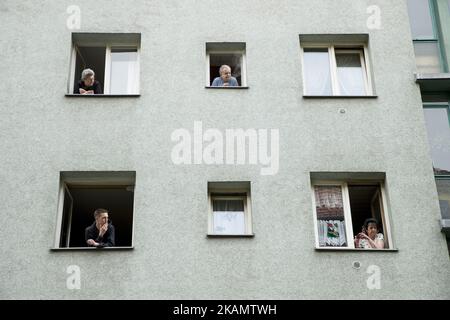 People at the windows watch a leftist May Day demonstration in the Kreuzberg district on May 1, 2017 in Berlin, Germany. May Day, or International Workers' Day, and became in Germany since 1933 a public holiday. May Day has also become known in Berlin for violent clashes between police and demonstrators in particular after 1987, whose 30th anniversary occurs this year. (Photo by Emmanuele Contini/NurPhoto) *** Please Use Credit from Credit Field *** Stock Photo