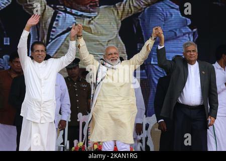 Sri Lankan President Maithripala Sirisena, left, Indian Prime Minister Narendra Modi, center, and Sri Lankan Prime Minister Ranil Wickremesinghe hold hands and wave to Sri Lankan tea plantation workers of Indian origin during a rally in Norwood, about 140 kilometers (87.5 miles) east of Colombo, Sri Lanka, Friday, May 12, 2017. During his two-day visit Modi participated in the United Nations celebration of Vesak or the day of birth, enlightenment and death of the Buddha and inaugurated a modern hospital for the benefit of tea plantation workers, ancestors of Indian laborers brought by the Brit Stock Photo