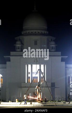 Bangladeshi workers take down a controversial statue of a sari-clad woman holding scales taken down amid tight security after months of protests by religious groups against what they called an un-Islamic Greek deity on May 26, 2017 in Dhaka. Bangladesh on May 26 removed a controversial statue depicting a goddess of justice outside its Supreme Court that religious hardliners had deemed un-Islamic, a move its creator said marked a victory for Islamists. (Photo by Sony Ramany/NurPhoto) *** Please Use Credit from Credit Field *** Stock Photo