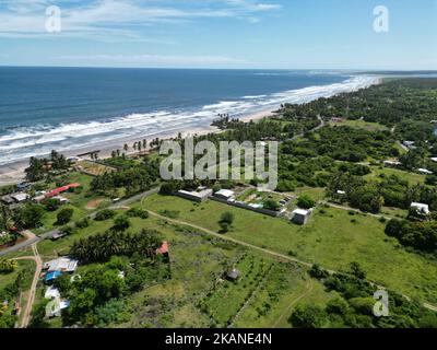 The ocean waves touching the coastline with the green beach view, Playa El Espino, Usulutan, El Salvador, aerial Stock Photo