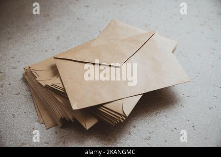 A stack of craft paper envelopes on a table. Stock Photo